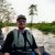 Petteri on a boat during a Kinabatangan River cruise, experiencing a Borneo safari surrounded by jungle.