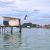 Bajau Laut child diving into crystal water from a stilt house roof in Malaysia