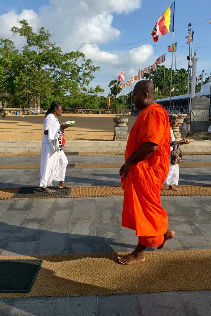 Buddhist believers and monk walking